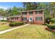 Charming brick home featuring a manicured lawn, symmetrical design, and inviting front entrance at 2350 Powers Ferry Se Dr, Marietta, GA 30067