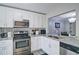 Modern kitchen with stainless steel appliances and a view into the dining and living area at 4095 Stillwater Dr, Duluth, GA 30096