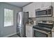 Modern kitchen featuring stainless steel appliances, white cabinets and a bright window at 4095 Stillwater Dr, Duluth, GA 30096