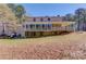 Backyard view of a beautiful home with a porch and lush green surroundings at 692 W Union Grove Cir, Auburn, GA 30011