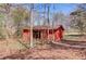Rustic red barn located on a wooded lot with mature trees adding to the privacy at 692 W Union Grove Cir, Auburn, GA 30011