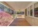 Covered front porch showcasing wood flooring and views of a lush, wooded landscape at 692 W Union Grove Cir, Auburn, GA 30011