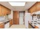 Kitchen with wood cabinets, white appliances and a view to the laundry area at 692 W Union Grove Cir, Auburn, GA 30011