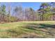Expansive grassy lot surrounded by mature trees under a clear blue sky at 692 W Union Grove Cir, Auburn, GA 30011