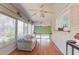 The sunroom features brick walls, hardwood floors, and many windows with natural light and nature views at 692 W Union Grove Cir, Auburn, GA 30011