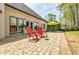 This backyard patio offers bright red Adirondack chairs, greenery, and sunny skies at 717 Robinson Farms Dr, Marietta, GA 30068