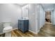 Hall bathroom showcases wood-look floors, blue vanity with white countertop, and modern lighting fixture at 717 Robinson Farms Dr, Marietta, GA 30068