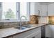 Close-up of a granite countertop with a stainless steel sink and stone backsplash at 717 Robinson Farms Dr, Marietta, GA 30068