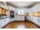 Gourmet kitchen with custom white cabinetry, stone backsplash, and high-end stainless steel appliances at 717 Robinson Farms Dr, Marietta, GA 30068