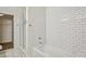 Bright bathroom featuring a white bathtub with white subway tile surround and glass shower door at 1100 Howell Mill Nw Rd # 408, Atlanta, GA 30318