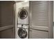 Laundry closet with stacked washer and dryer and louvered doors at 1100 Howell Mill Nw Rd # 408, Atlanta, GA 30318