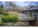 View of a cozy backyard with a wooden deck, stone foundation and lush greenery at 120 Maryeanna Ne Dr, Atlanta, GA 30342