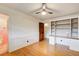 Spacious bedroom featuring a ceiling fan, hardwood floors, and built-in shelving with a connected full bathroom at 120 Maryeanna Ne Dr, Atlanta, GA 30342