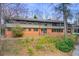 Charming two-story home with a brick facade and a lush, natural landscape around the property at 120 Maryeanna Ne Dr, Atlanta, GA 30342