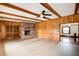 Spacious living room with wood paneling, brick fireplace, ceiling fan, and neutral carpeting at 120 Maryeanna Ne Dr, Atlanta, GA 30342