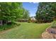 Expansive backyard with lush green lawn, mature trees, and stone path creating a serene outdoor space at 1239 Bonshaw Trl, Marietta, GA 30064