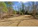 Spacious backyard with grass lawn, mature trees, and decorative landscaping near wooded area at 1239 Bonshaw Trl, Marietta, GA 30064