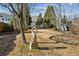 Spacious backyard with mature trees, lawn, landscaping, and sculpted stone art piece at 1239 Bonshaw Trl, Marietta, GA 30064