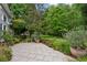 Landscaped backyard features a stone patio with lush green foliage and an expansive lawn at 1239 Bonshaw Trl, Marietta, GA 30064
