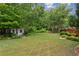 Lush backyard with a charming shed surrounded by trees and manicured landscaping at 1239 Bonshaw Trl, Marietta, GA 30064