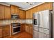 Well-lit kitchen with stainless steel appliances, wood cabinets, granite countertops and gas cooktop at 1239 Bonshaw Trl, Marietta, GA 30064