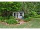 Charming shed with French doors and decorative accents surrounded by lush landscaping at 1239 Bonshaw Trl, Marietta, GA 30064