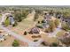 Expansive aerial view of a red brick home with manicured lawn and mature trees in a neighborhood with a pond at 179 Country Club Dr, Hiram, GA 30141