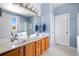 Bathroom features double sinks with wood cabinets and a large mirror with decorative lighting at 179 Country Club Dr, Hiram, GA 30141