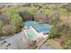 Aerial view of a community pool and tennis courts nestled among mature trees, providing recreational opportunities at 179 Country Club Dr, Hiram, GA 30141