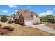 Side view of a charming home featuring a well-maintained lawn, beautiful brick accents, and an attached garage at 179 Country Club Dr, Hiram, GA 30141