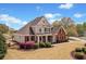 Inviting home showcasing a well-maintained lawn, lush landscaping, and a charming front porch at 179 Country Club Dr, Hiram, GA 30141