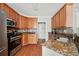 Traditional kitchen with stainless steel appliances, granite countertops, tile backsplash and cherry wood cabinetry at 179 Country Club Dr, Hiram, GA 30141