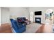Bright living room featuring a fireplace, hardwood floors, and a comfortable blue sofa set at 179 Country Club Dr, Hiram, GA 30141