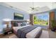 This main bedroom boasts blue walls, a ceiling fan, and large windows with a view of the outside at 179 Country Club Dr, Hiram, GA 30141