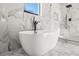 A luxurious tub is surrounded by elegant marble walls in this modern bathroom at 2018 Presley Ne Way, Atlanta, GA 30317