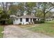 A bright one-story home with manicured landscaping, a long driveway and beautiful surrounding trees at 3216 Woodview Se Dr, Smyrna, GA 30082