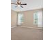 Spacious bedroom with neutral walls, carpeted floors, and two bright windows with curtains at 709 Mountain Laurel Dr, Canton, GA 30114