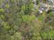 Aerial view showcasing a house with a backyard pool and surrounding greenery at 1068 Gwens Sw Trl, Lilburn, GA 30047