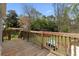 Outdoor deck with wooden railing overlooking a play area, a lush backyard and wooded perimeter at 1068 Gwens Sw Trl, Lilburn, GA 30047
