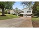 Classic split-level home featuring a two-car garage, manicured lawn, and a cozy, covered front entry at 1068 Gwens Sw Trl, Lilburn, GA 30047