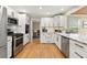 Updated kitchen featuring stainless steel appliances, white cabinetry, and an open layout to the breakfast area at 1068 Gwens Sw Trl, Lilburn, GA 30047