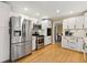 Modern kitchen with stainless steel appliances, white cabinets, and hardwood flooring at 1068 Gwens Sw Trl, Lilburn, GA 30047