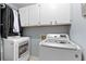 Functional laundry room with modern washer and dryer, plus convenient overhead storage cabinets at 1068 Gwens Sw Trl, Lilburn, GA 30047