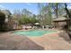 Backyard oasis featuring a kidney-shaped pool, poolside seating, outdoor kitchen, and lush landscaping at 1068 Gwens Sw Trl, Lilburn, GA 30047
