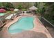 Backyard oasis featuring a kidney-shaped pool, poolside seating, outdoor kitchen, and lush landscaping at 1068 Gwens Sw Trl, Lilburn, GA 30047