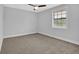 Neutral bedroom with light grey walls, carpeted floor, ceiling fan, and natural light from a window at 1449 Hoy Taylor Dr, Norcross, GA 30093