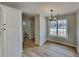 Bright dining area with modern chandelier, wood-look floors, and a view of the neighborhood through a large window at 4480 Maple Valley Dr, Cumming, GA 30040