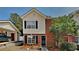Charming two-story townhouse with a brick facade, vinyl siding, black shutters, and a well-manicured lawn at 4480 Maple Valley Dr, Cumming, GA 30040