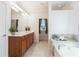 Bathroom featuring a double vanity, soaking tub, and separate area for a toilet at 4520 Vanadium Bnd, Cumming, GA 30040