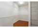 Walk-in closet with built-in shelving and hardwood floors at 4520 Vanadium Bnd, Cumming, GA 30040